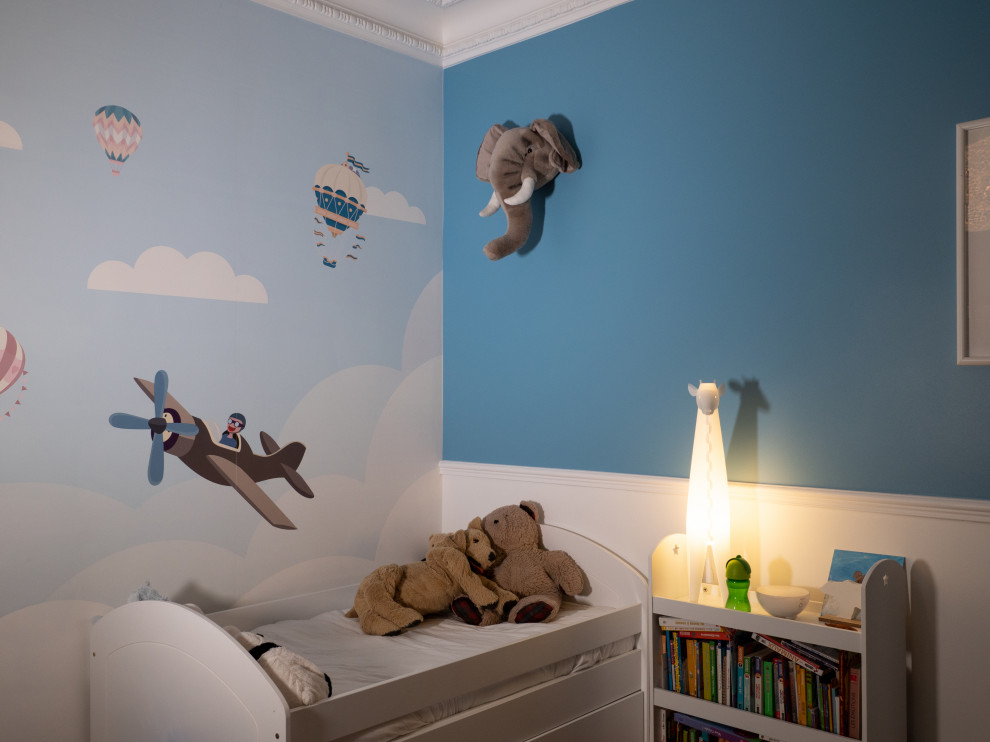 Diseño de dormitorio infantil de 1 a 3 años tradicional renovado de tamaño medio con paredes azules y suelo de madera clara