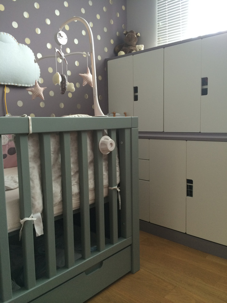 Пример оригинального дизайна: комната для малыша среднего размера в современном стиле с фиолетовыми стенами и светлым паркетным полом для девочки