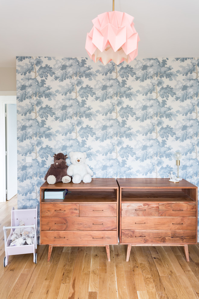 Idée de décoration pour une chambre de bébé fille tradition de taille moyenne avec parquet clair, un sol beige et un mur multicolore.