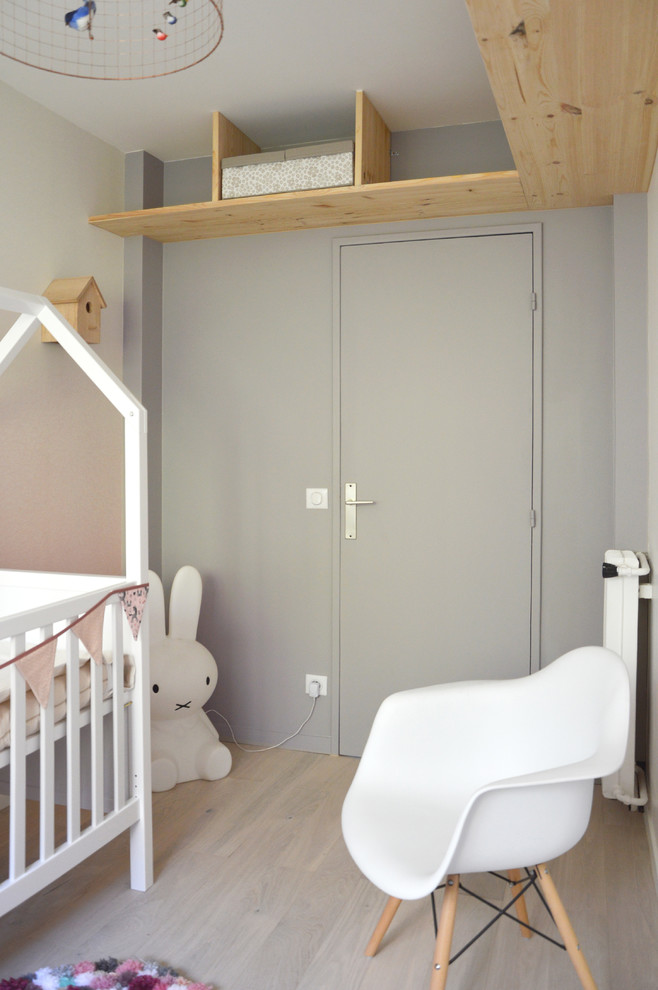 Exemple d'une chambre de bébé romantique avec un mur rose et parquet clair.