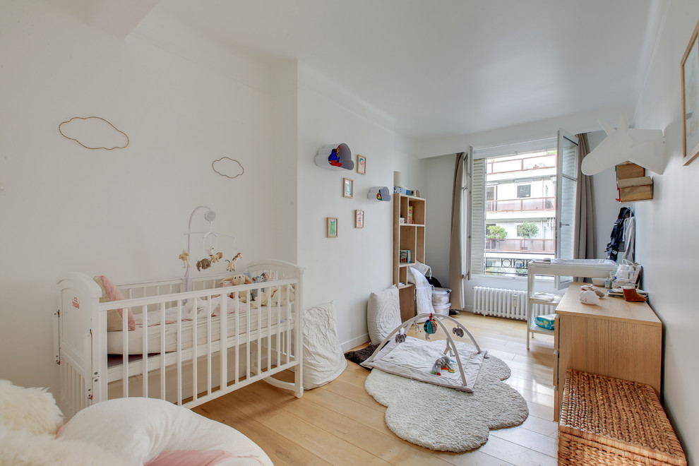 Mittelgroßes, Neutrales Modernes Babyzimmer mit weißer Wandfarbe, hellem Holzboden und braunem Boden in Paris