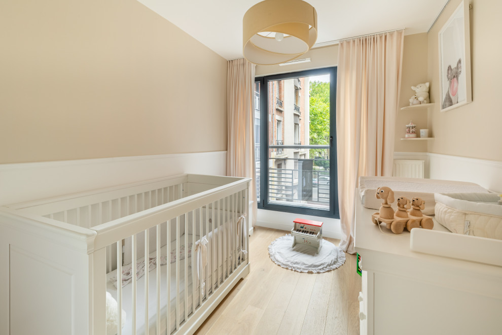 Aménagement d'une chambre de bébé fille contemporaine de taille moyenne avec un mur beige, parquet clair et un sol beige.