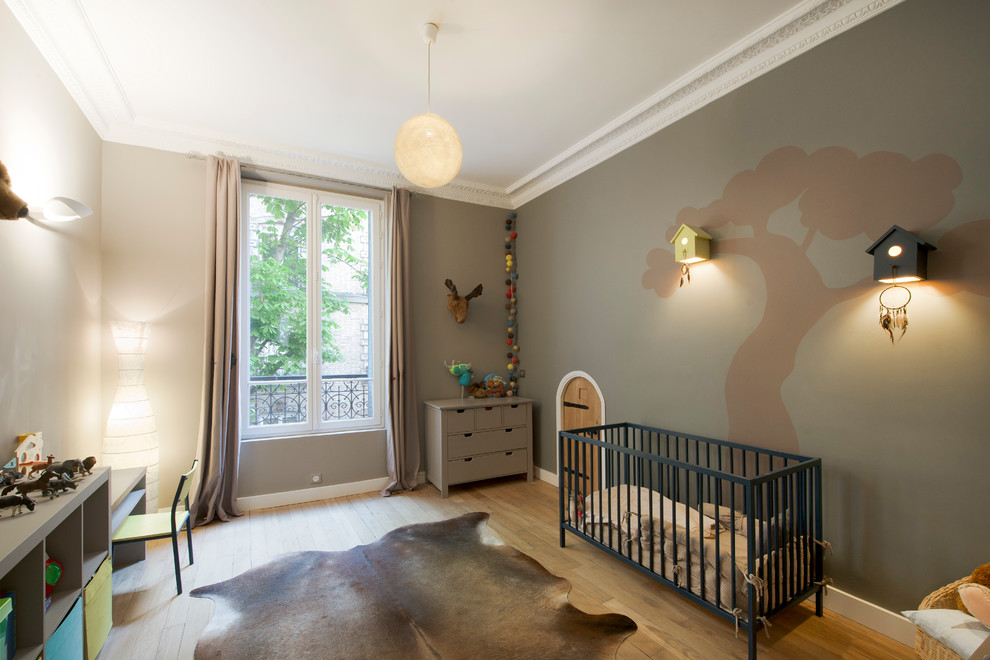 Cette image montre une chambre de bébé garçon design de taille moyenne avec parquet clair, un mur marron et un sol marron.
