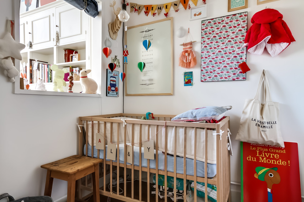 Cette image montre une petite chambre de bébé neutre bohème avec un mur blanc.