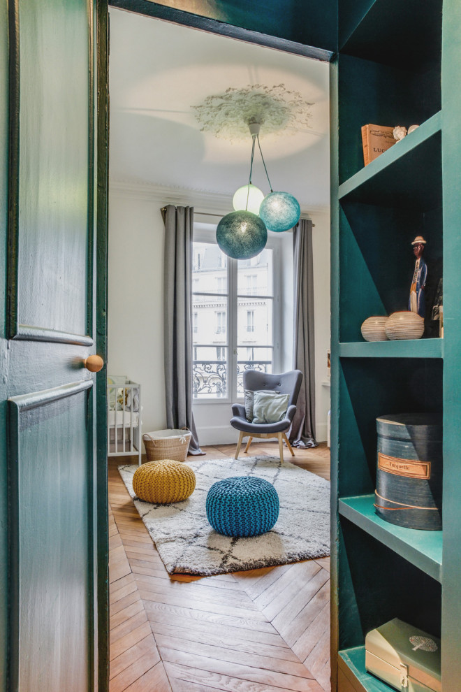 Design ideas for a medium sized scandinavian gender neutral nursery in Paris with white walls, light hardwood flooring and brown floors.