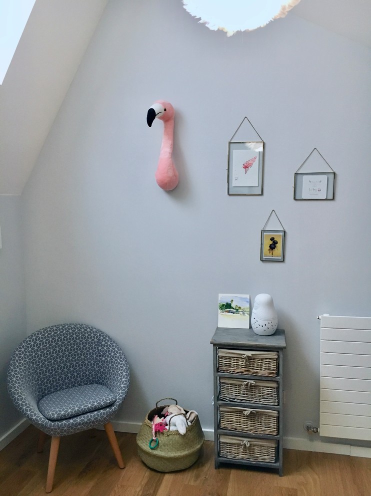 Cette photo montre une chambre de bébé fille chic de taille moyenne avec un mur gris et parquet clair.