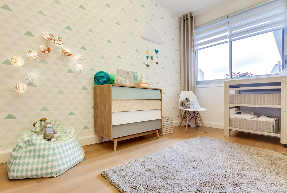 Diseño de habitación de bebé neutra nórdica de tamaño medio con paredes blancas, suelo de madera clara y suelo beige