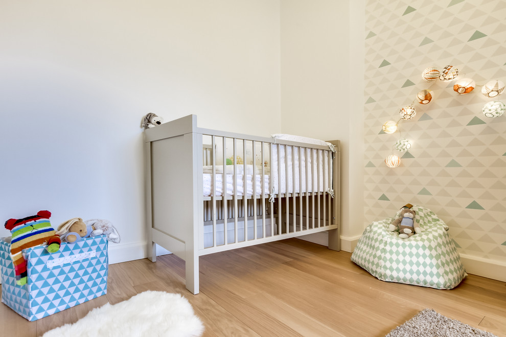 Réalisation d'une chambre de bébé neutre nordique de taille moyenne avec un mur blanc, parquet clair et un sol beige.