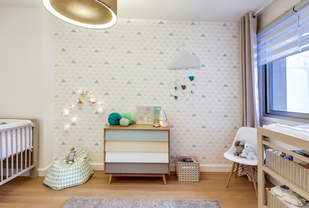 Inspiration pour une chambre de bébé neutre nordique de taille moyenne avec un mur blanc, parquet clair et un sol beige.