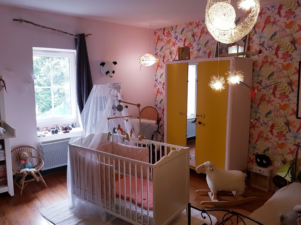Cette photo montre une grande chambre de bébé fille éclectique avec un mur rose, parquet clair et un sol beige.