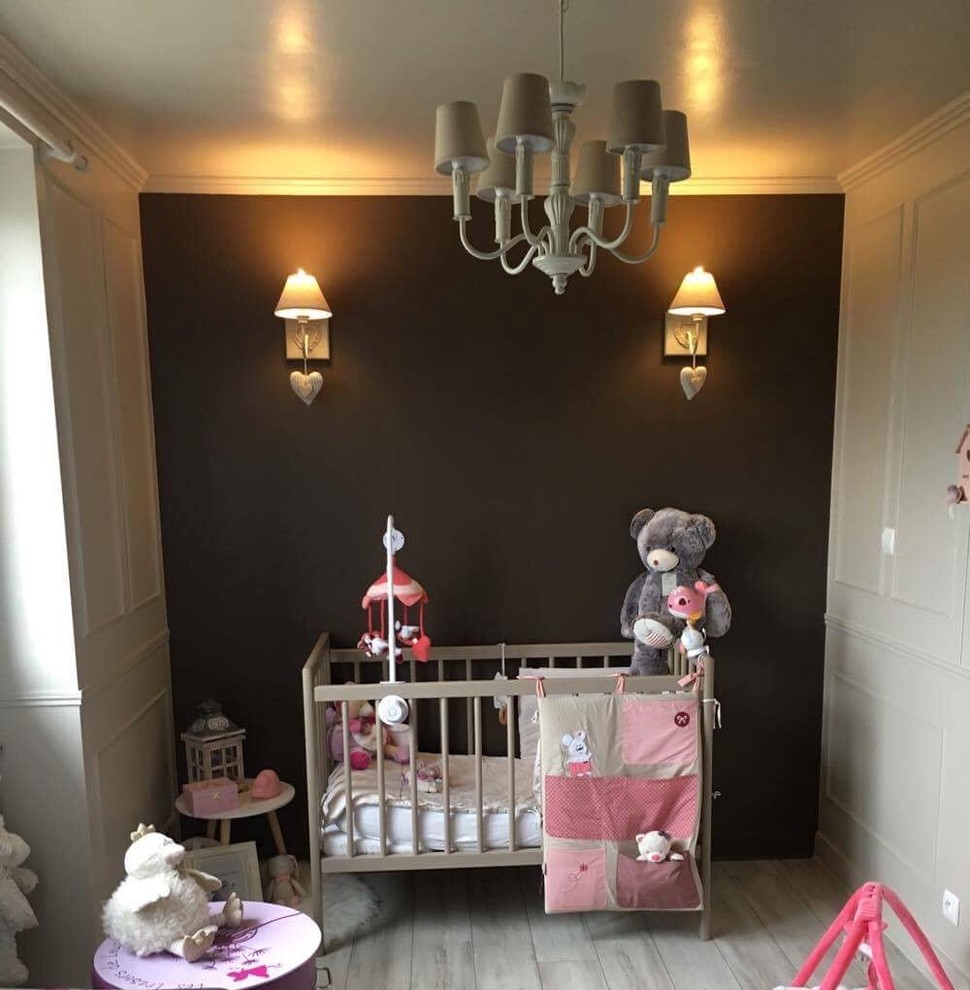 Immagine di una cameretta per neonata shabby-chic style di medie dimensioni con pareti beige, pavimento in laminato e pavimento beige