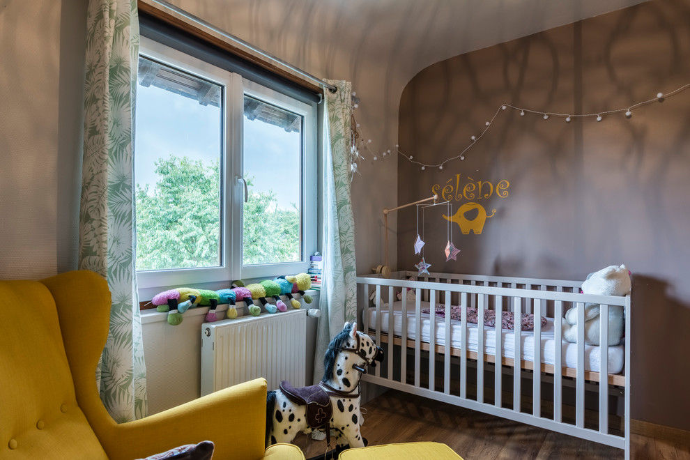 Cette image montre une chambre de bébé fille bohème avec un mur gris.