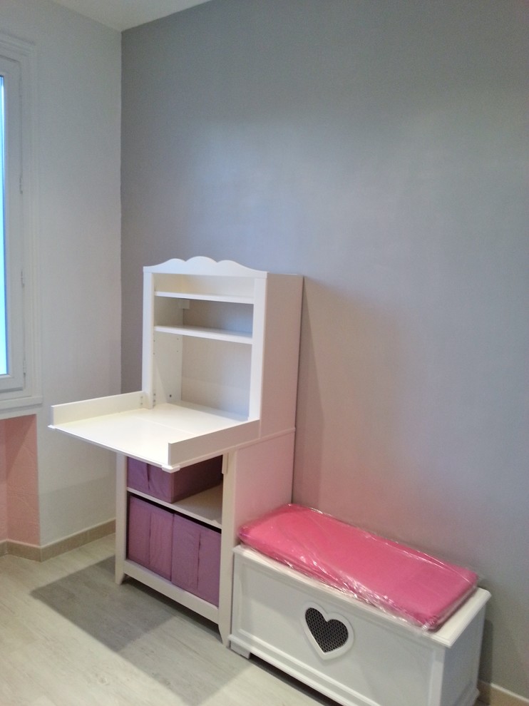 Cette image montre une petite chambre de bébé fille traditionnelle avec un mur gris et un sol gris.