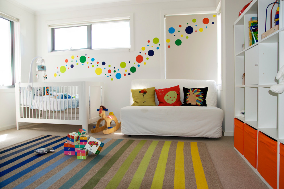 This is an example of a medium sized modern nursery for boys in Sydney with white walls, carpet and beige floors.