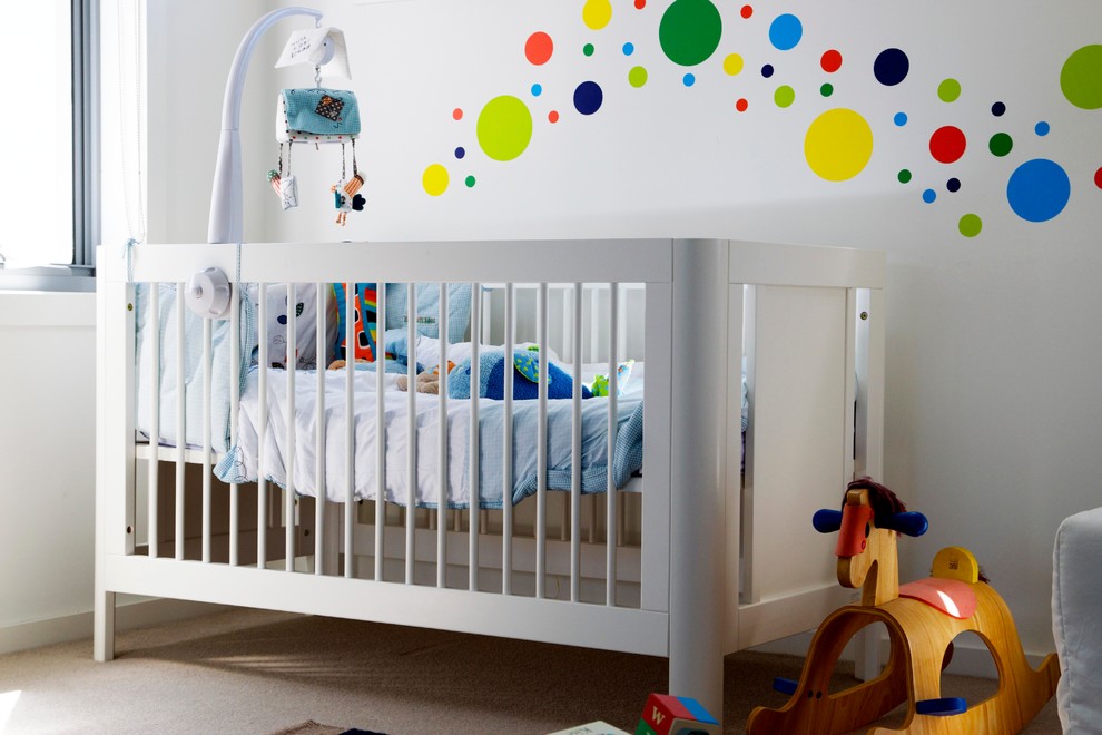 Medium sized modern nursery for boys in Sydney with white walls, carpet and beige floors.