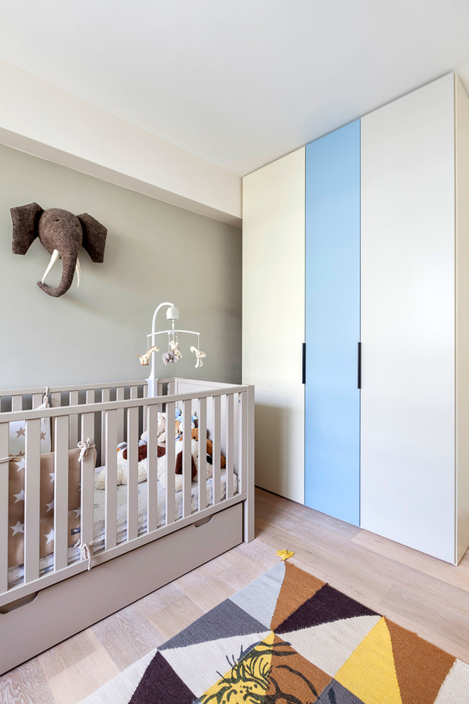 Inspiration for a medium sized contemporary nursery for boys in Paris with beige walls, light hardwood flooring and beige floors.