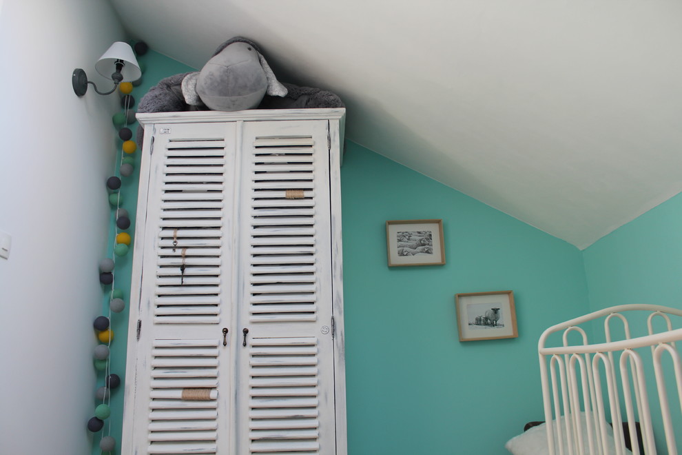 Immagine di una cameretta per neonati neutra country di medie dimensioni con parquet chiaro e pareti blu