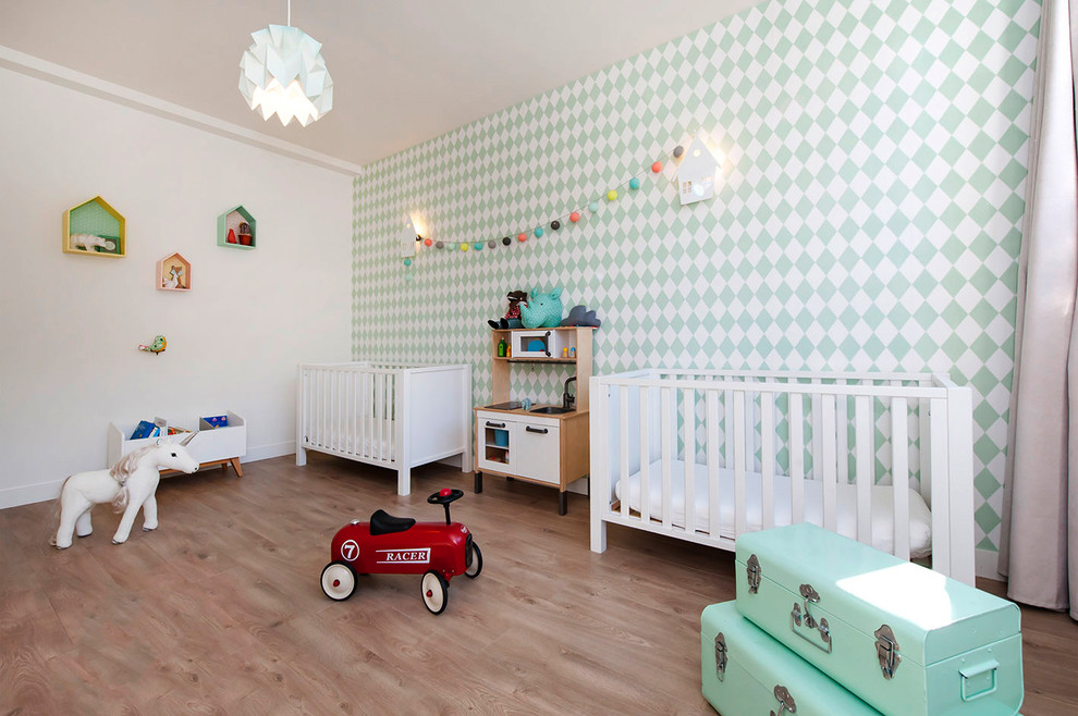 Cette image montre une grande chambre de bébé nordique avec parquet clair, un mur blanc et un sol beige.