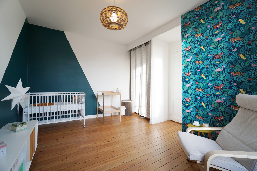 Réalisation d'une grande chambre de bébé garçon design avec un mur blanc, un sol en bois brun, un sol marron et du papier peint.