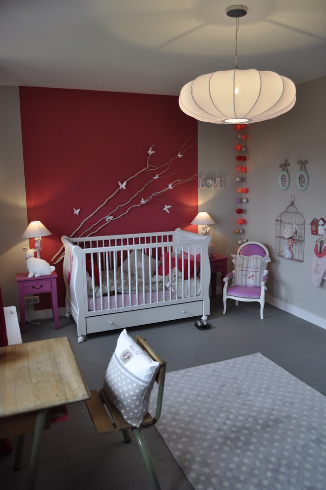 Design ideas for a medium sized eclectic nursery for girls in Paris with red walls, grey floors and a feature wall.