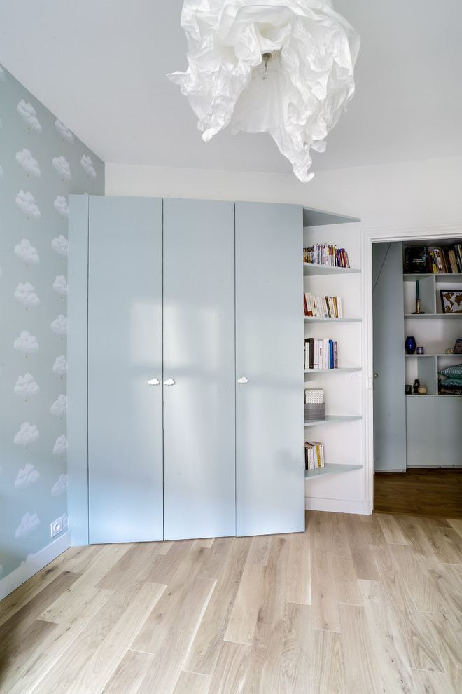 Ispirazione per una cameretta per neonati neutra design con pareti bianche e parquet chiaro