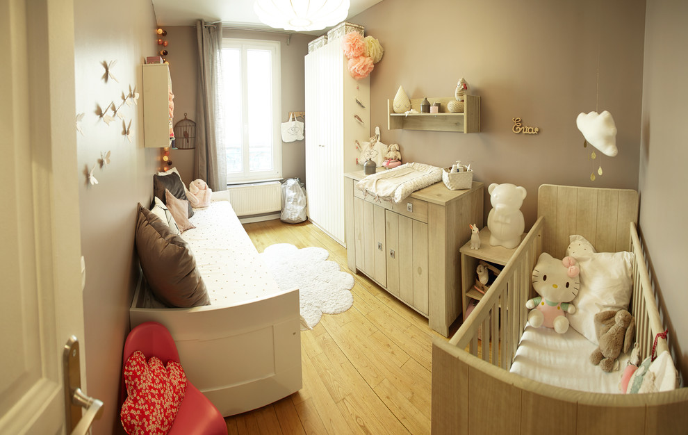 Idées déco pour une chambre de bébé fille classique de taille moyenne avec parquet clair, un mur blanc et un sol marron.