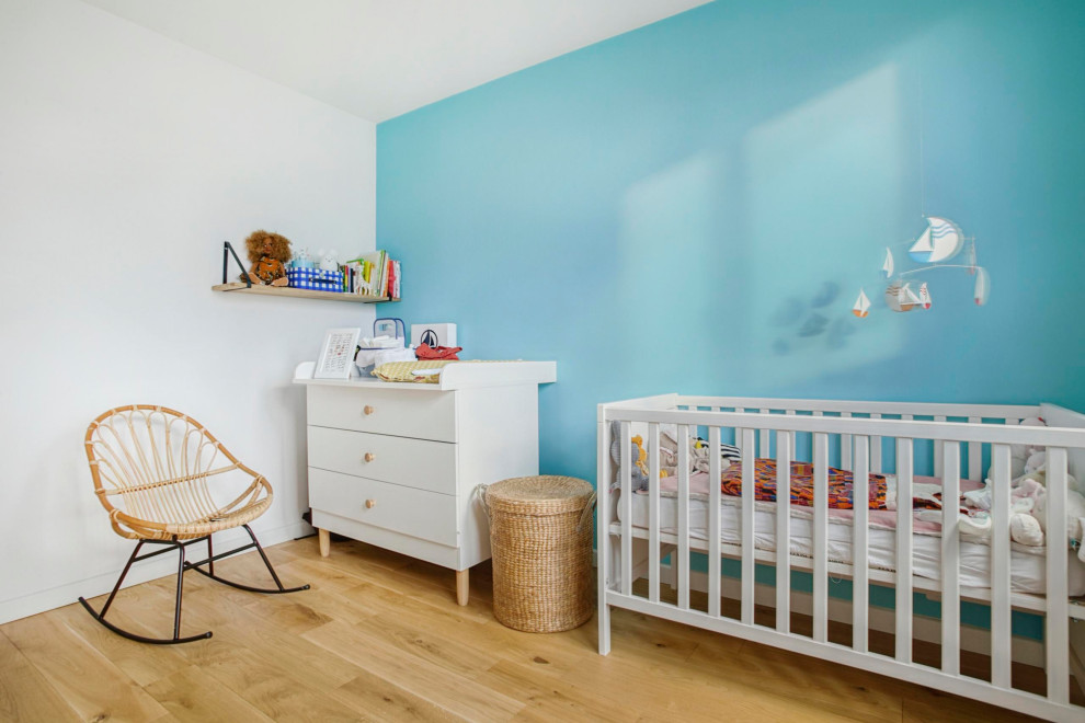 Inspiration för mellanstora moderna könsneutrala babyrum, med blå väggar, mellanmörkt trägolv och brunt golv