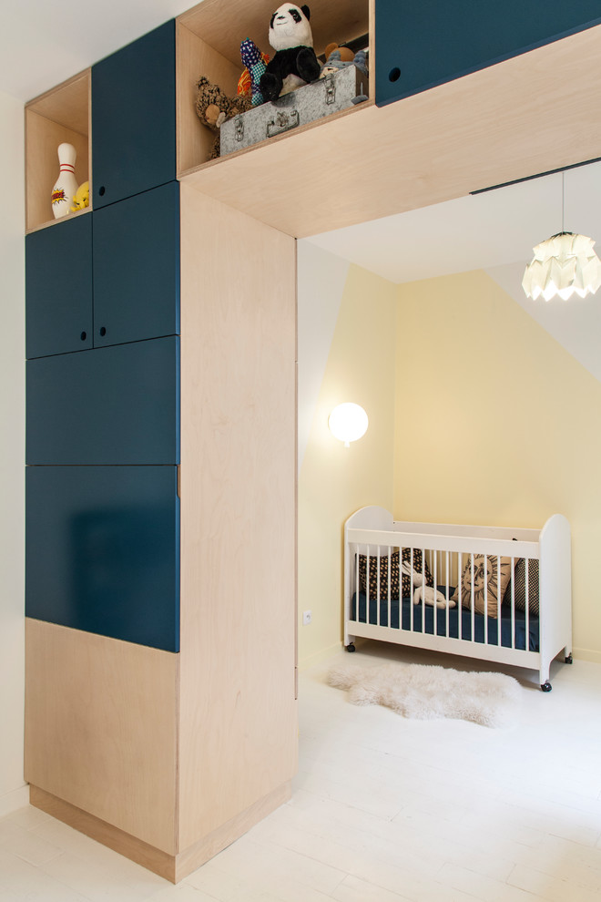 Immagine di una cameretta per neonati neutra contemporanea con pareti gialle e pavimento bianco