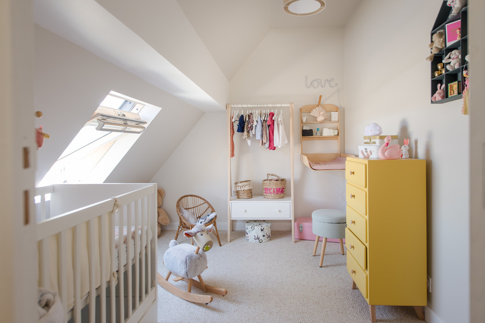 Diseño de habitación de bebé niña contemporánea con paredes beige, moqueta y suelo beige