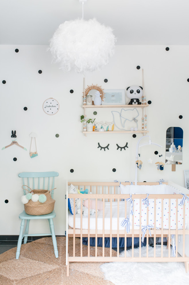 Idée de décoration pour une chambre de bébé design avec un mur blanc et un sol gris.