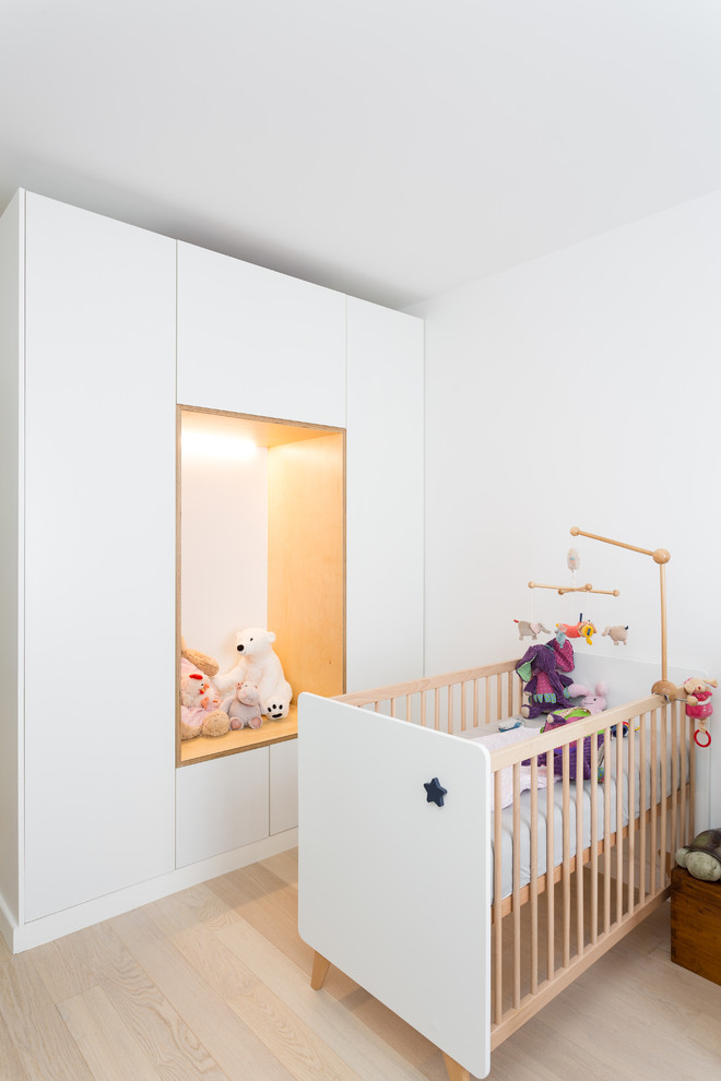 Пример оригинального дизайна: нейтральная комната для малыша среднего размера в современном стиле с белыми стенами, светлым паркетным полом и бежевым полом