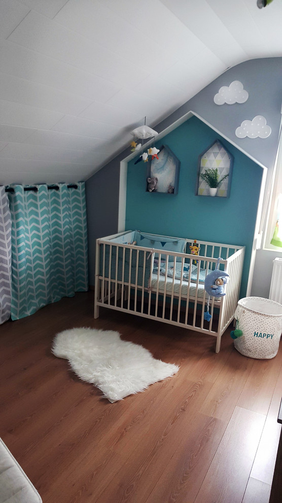 Idee per una piccola cameretta per neonato scandinava con pareti grigie e pavimento in legno massello medio