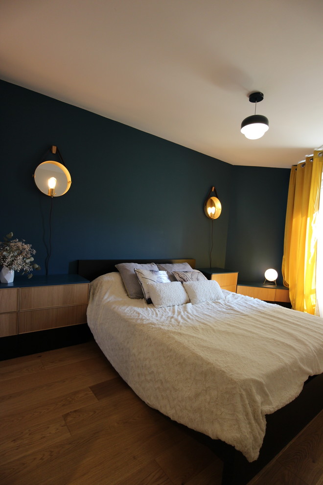 Ispirazione per una piccola camera matrimoniale design con pareti blu, parquet chiaro, nessun camino e pavimento marrone