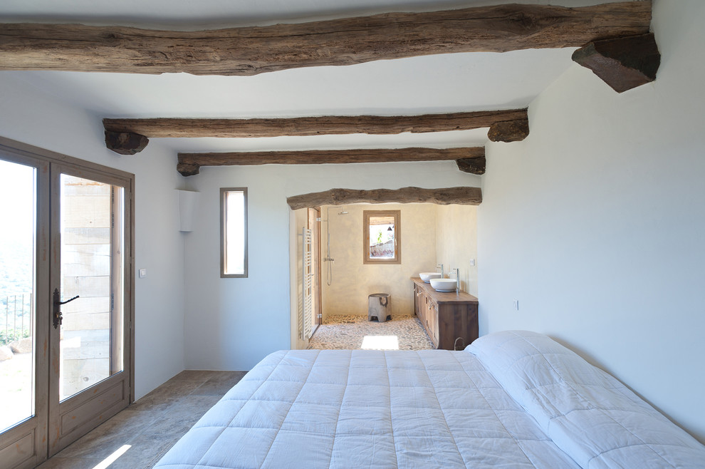 Example of a farmhouse bedroom design in Paris with white walls