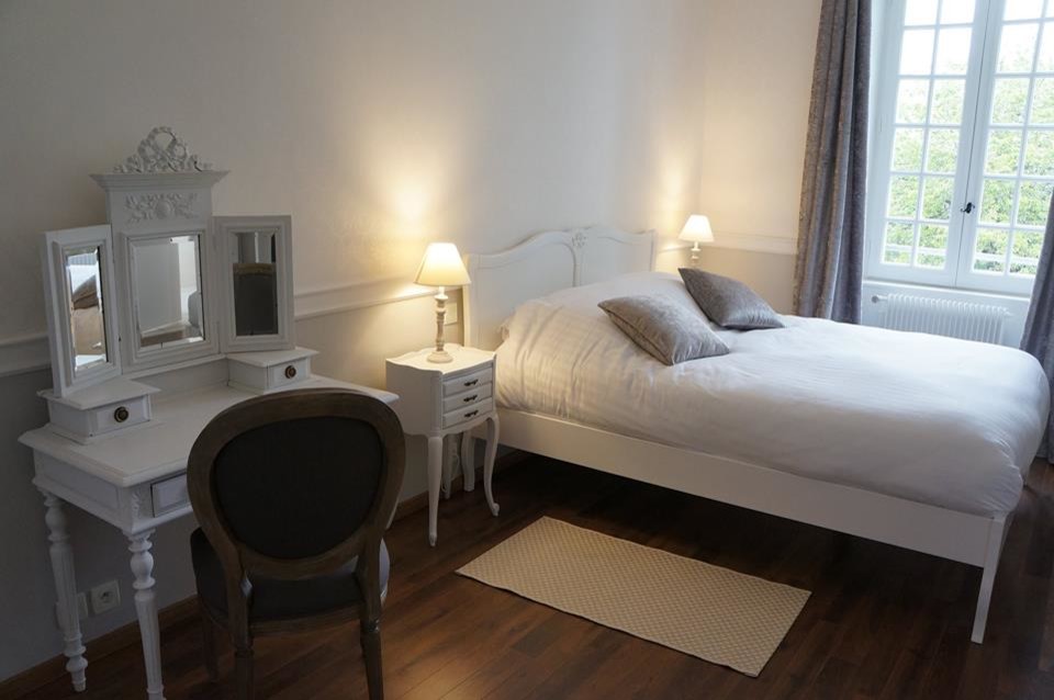 Inspiration för klassiska sovrum, med vita väggar och mellanmörkt trägolv