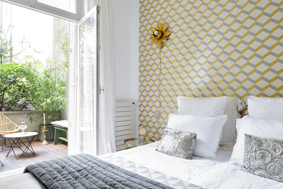 Example of a mid-sized trendy master light wood floor bedroom design in Paris with white walls and no fireplace