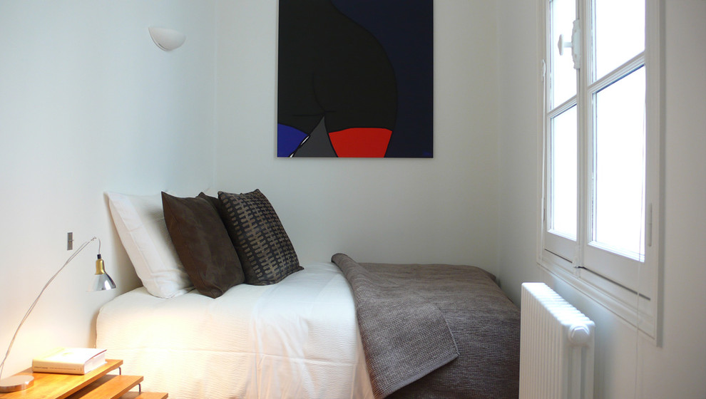 Immagine di una camera da letto design con pareti bianche
