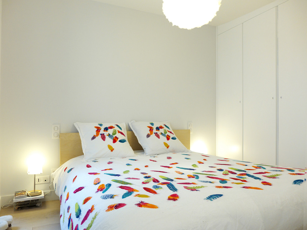Foto de dormitorio actual de tamaño medio con paredes blancas y suelo de madera clara