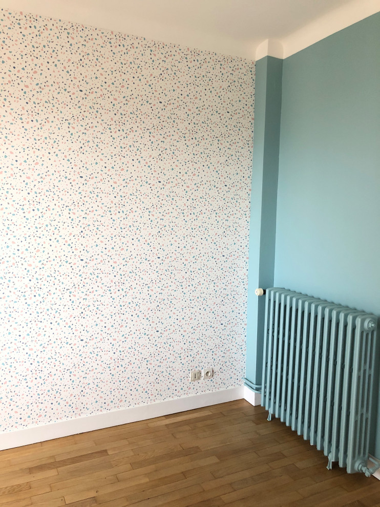 Imagen de habitación de invitados actual grande con paredes azules y suelo de madera clara