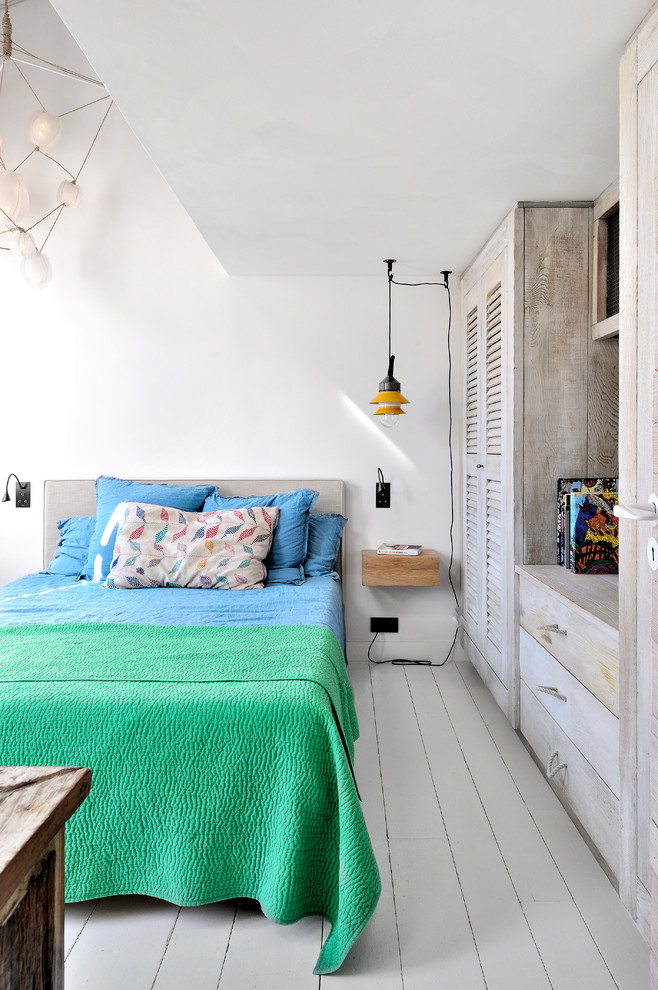 Modelo de dormitorio bohemio con paredes blancas, suelo de madera pintada y suelo blanco