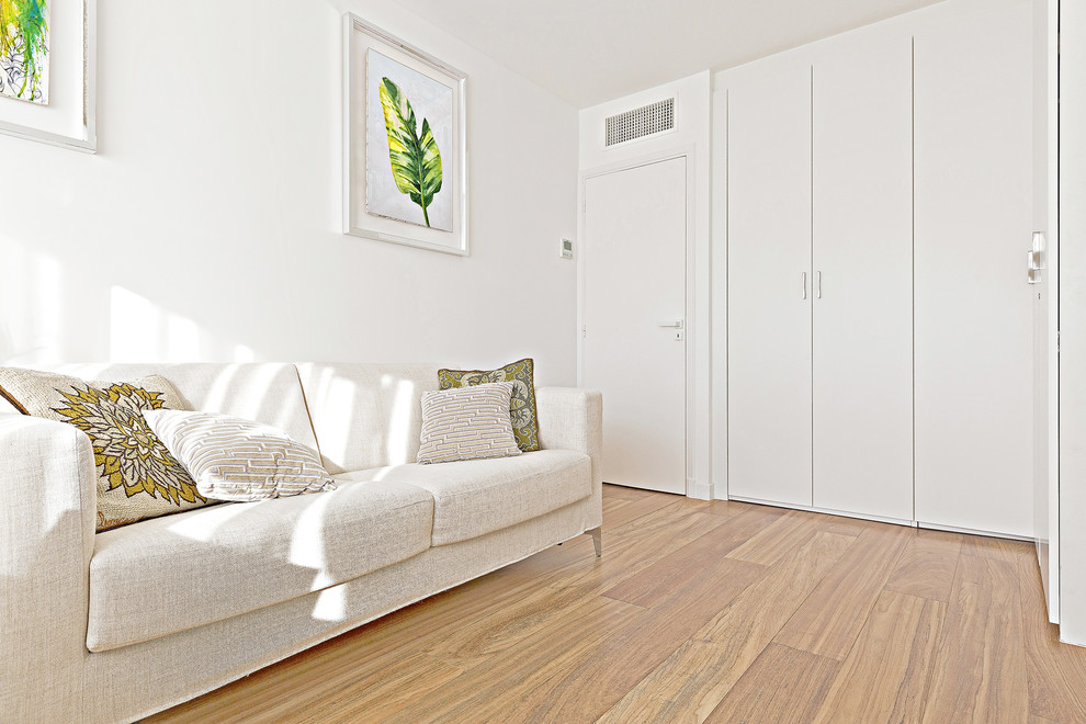 Exemple d'une chambre exotique avec un mur blanc et un sol marron.