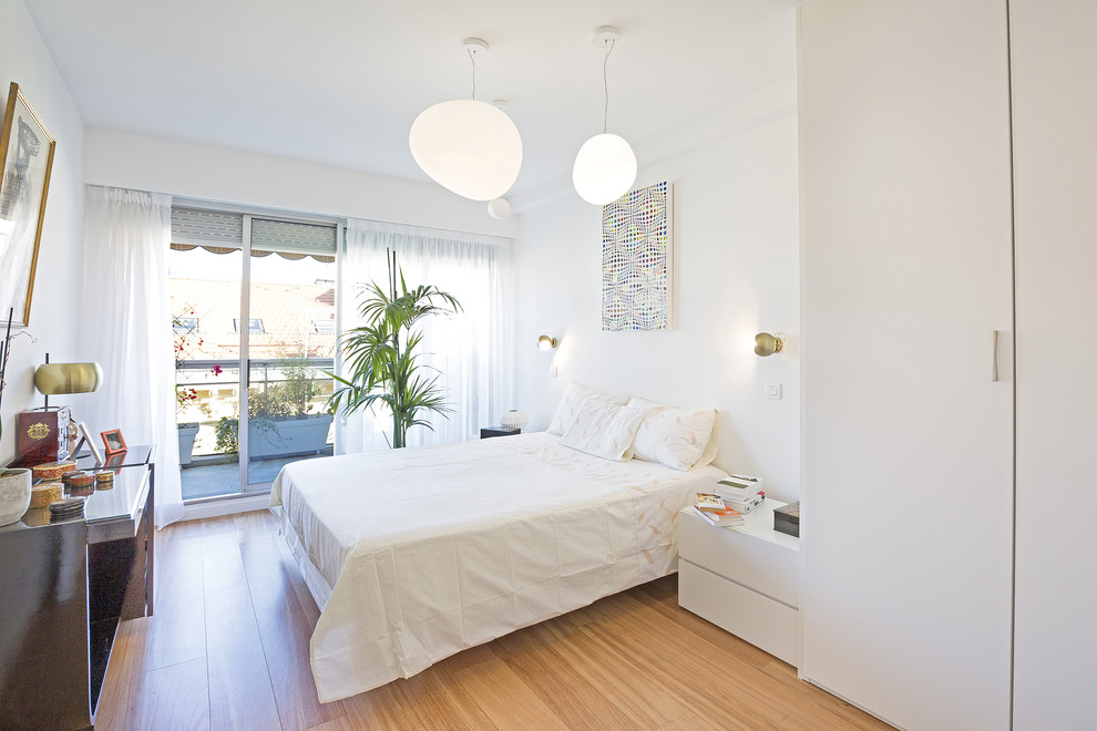 Ispirazione per una camera da letto tropicale con pareti bianche e pavimento marrone