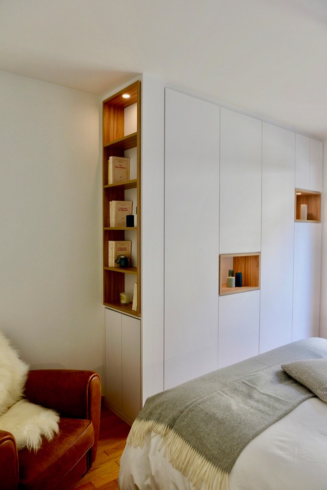 Ispirazione per una piccola camera matrimoniale contemporanea con pareti bianche, parquet chiaro e pavimento marrone