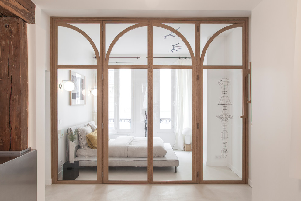 Стильный дизайн: спальня в современном стиле с белыми стенами, бетонным полом и серым полом - последний тренд