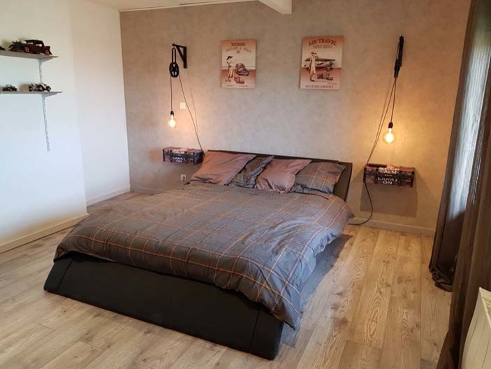 Свежая идея для дизайна: хозяйская спальня среднего размера в стиле лофт с бежевыми стенами, полом из ламината и коричневым полом - отличное фото интерьера