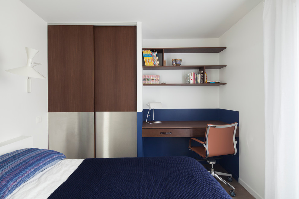 Esempio di una piccola camera da letto minimalista con pavimento in legno massello medio