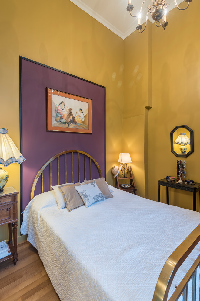 Ispirazione per una camera degli ospiti boho chic con pareti multicolore, pavimento in legno massello medio e pavimento marrone