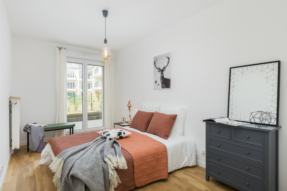 Inspiration for a scandinavian guest light wood floor and beige floor bedroom remodel in Other with white walls