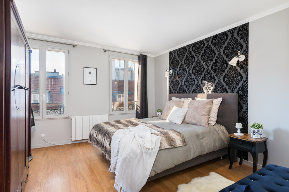 На фото: спальня в современном стиле с серыми стенами, паркетным полом среднего тона, коричневым полом и акцентной стеной с