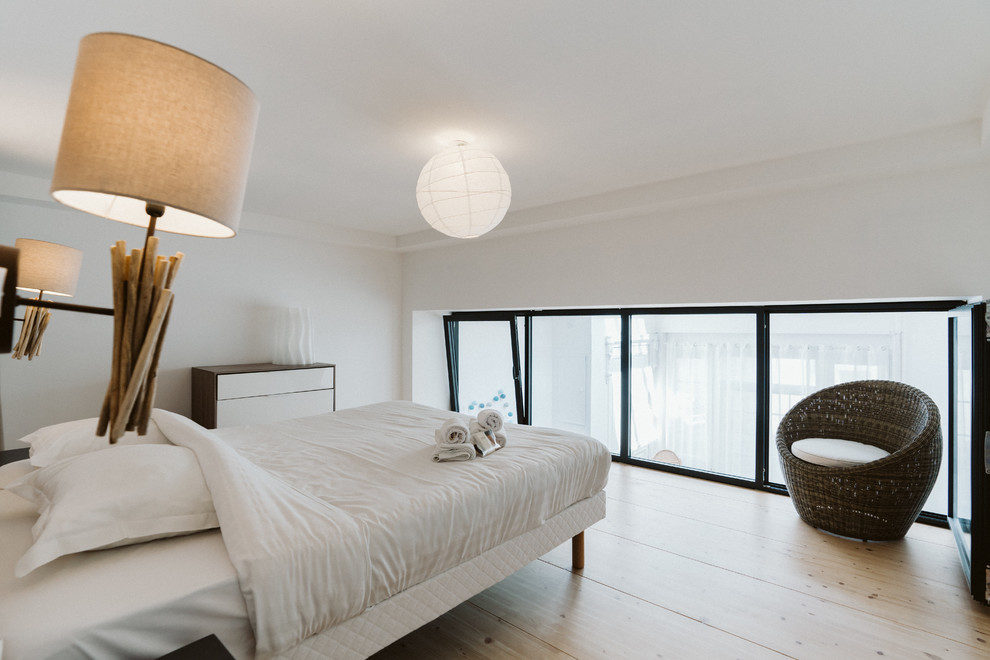 Kleines Modernes Hauptschlafzimmer ohne Kamin mit weißer Wandfarbe, hellem Holzboden und braunem Boden in Lille